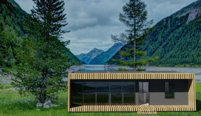 Vista de una casa modular en un valle frente al lago con dos árboles