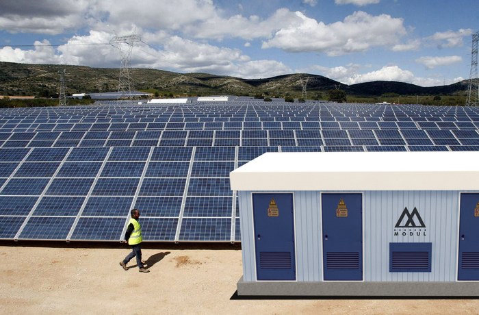 Caseta eléctrica enfrente a módulos solares en terreno