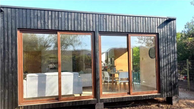 Vista exterior de una casa modular tiny modul con Living y comedor a la vista desde fuera