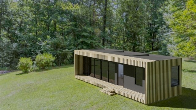 Casa modular en un terreno con árboles de fondo